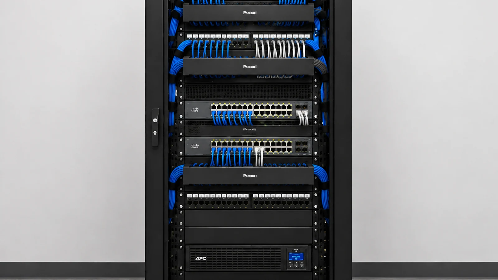 Floor-standing network rack with neatly organized blue patch cords and active network equipment